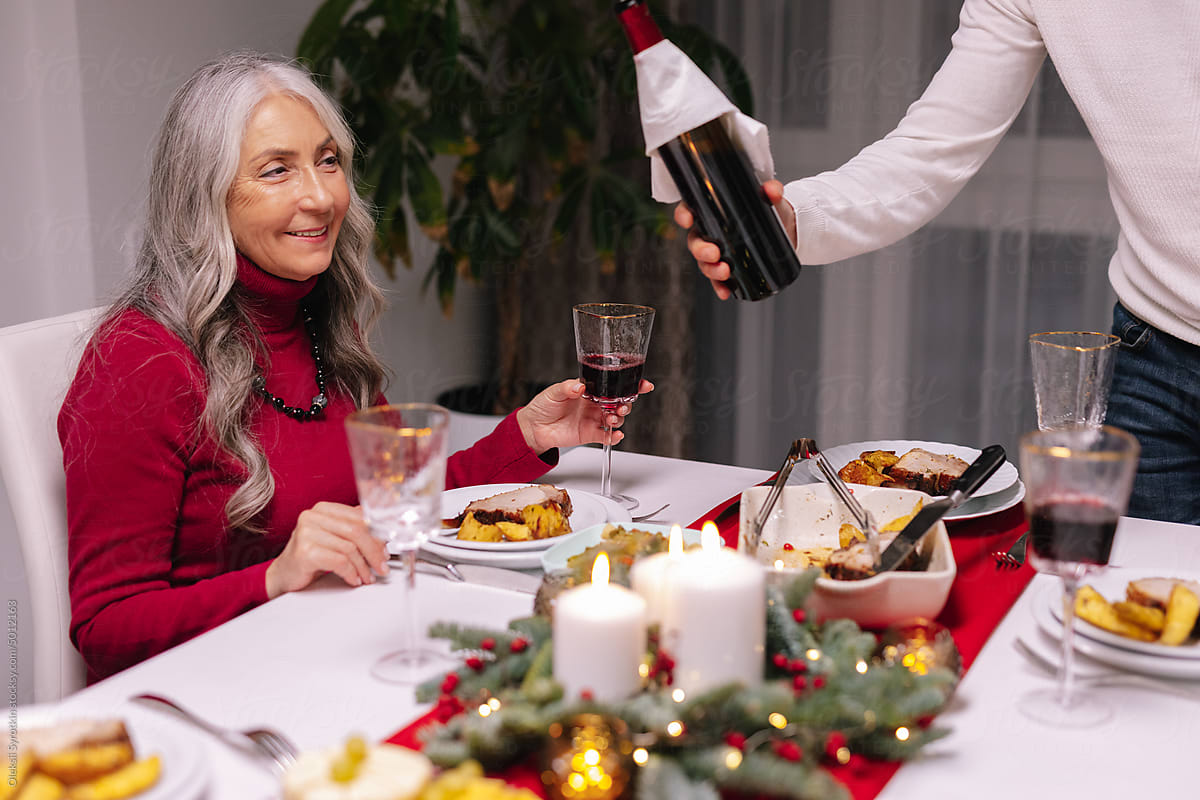 Grandmother, senior, boomer, pour, red wine, celebrate, dinner table