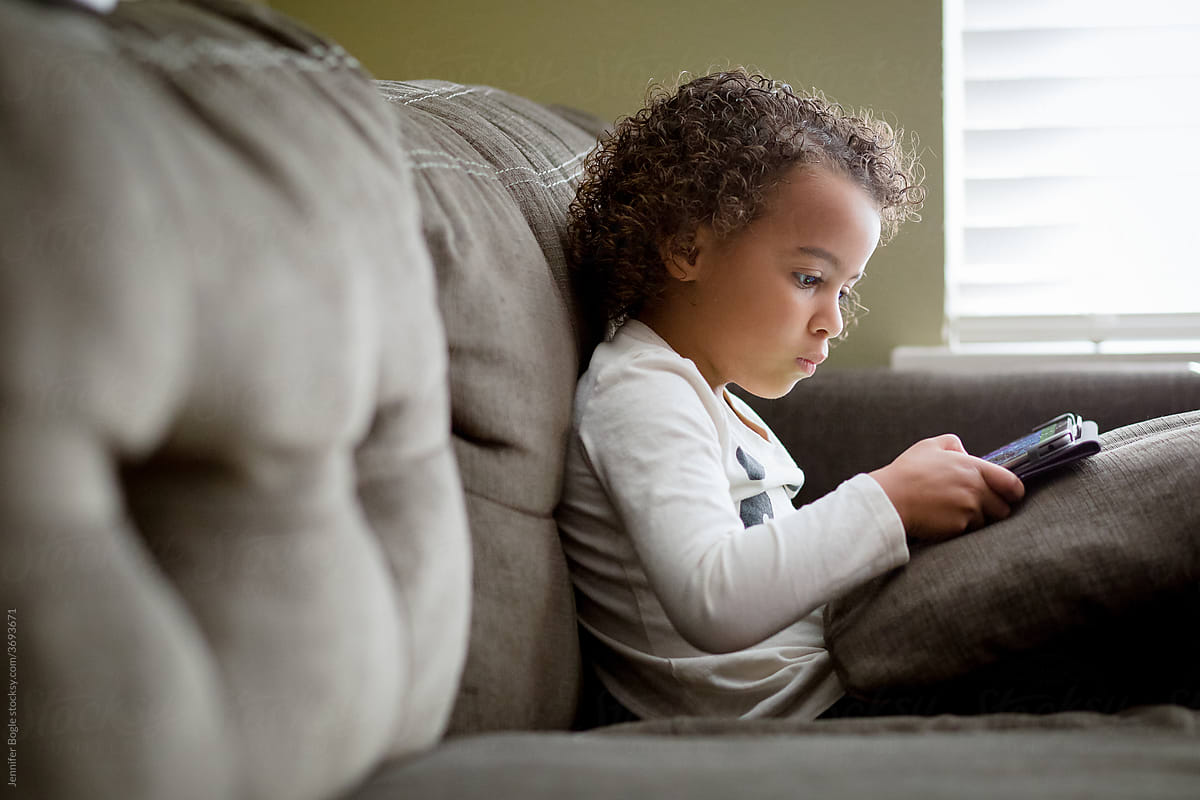 Profile of Preschooler on tablet on couch