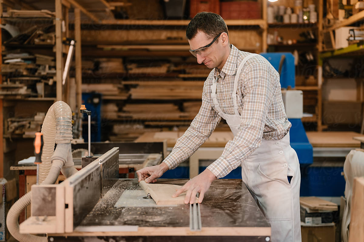 Carpenter grinding edge of wooden part