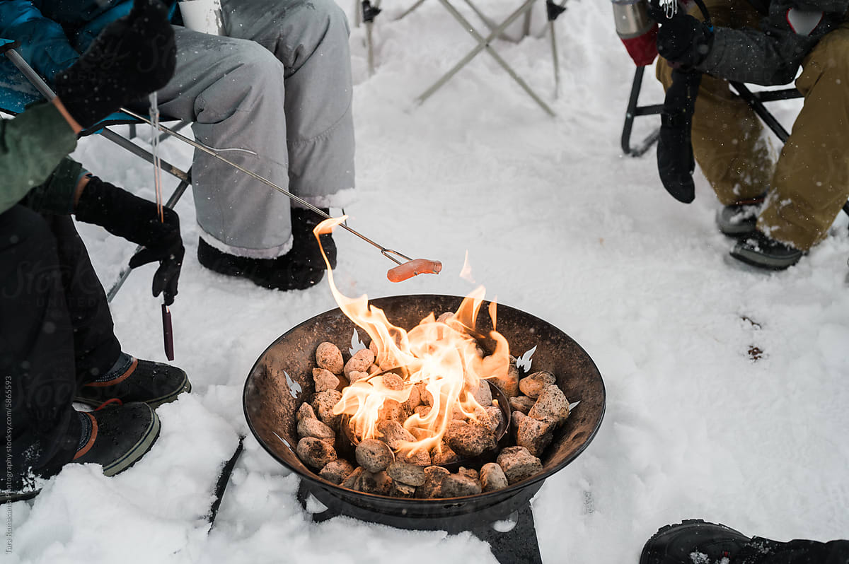Hotdog grilled over a fire pit in the snow