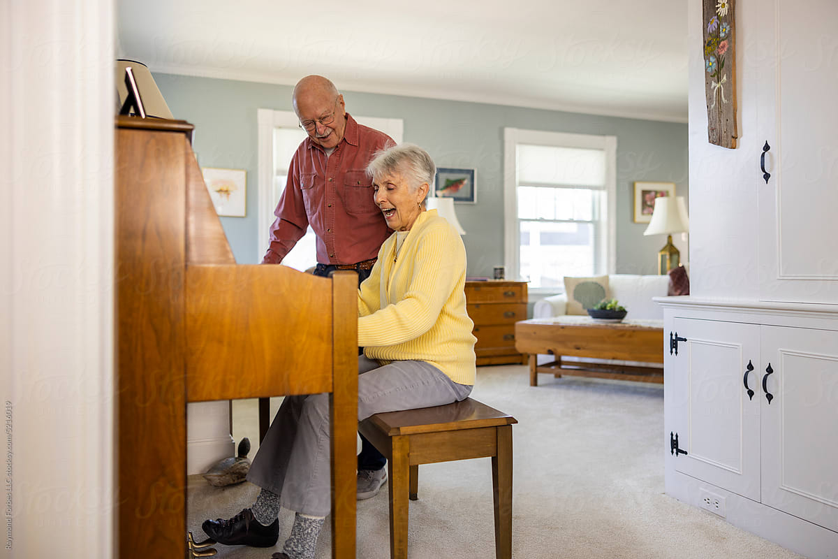 Family Piano playing for elderly senior fun couple singing