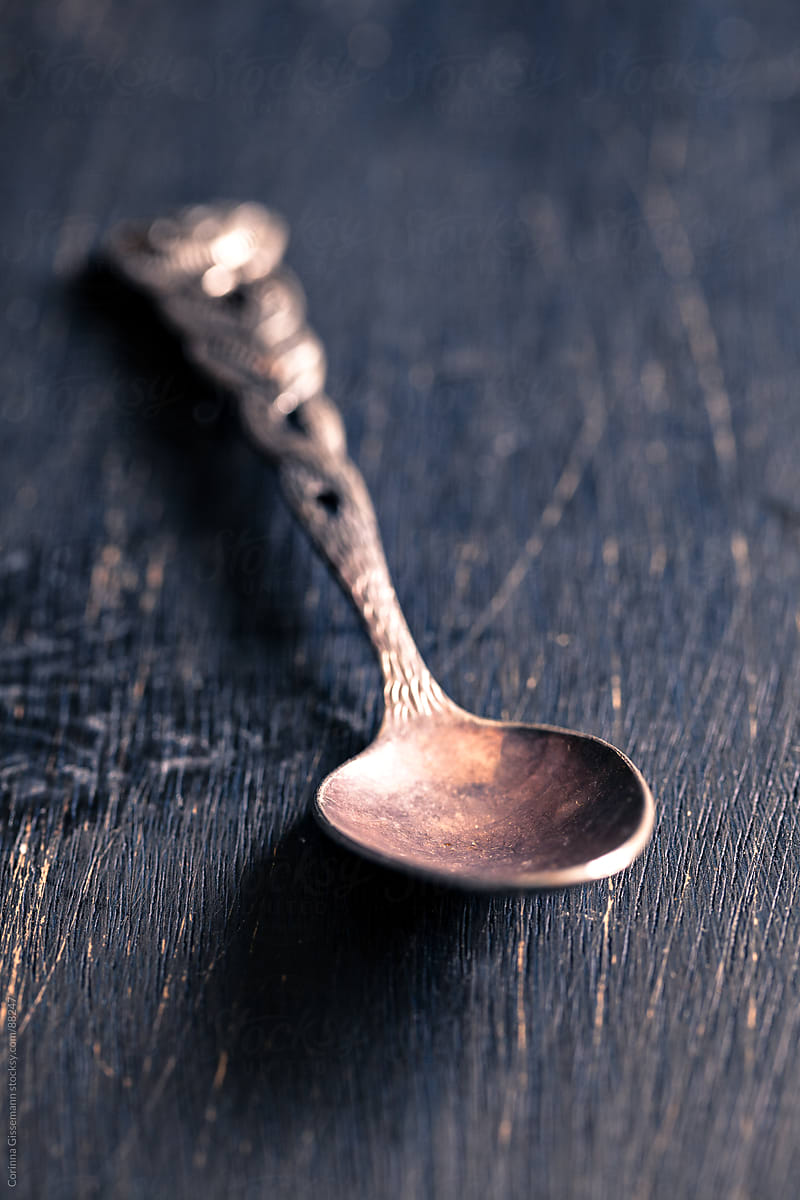 old silver spoon on wooden surface