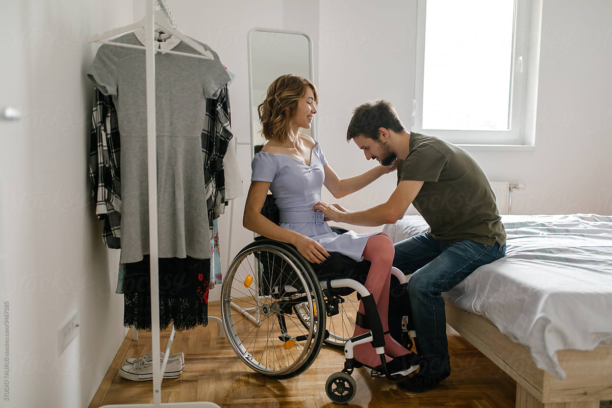 Young woman in a wheelchair changing her clothes