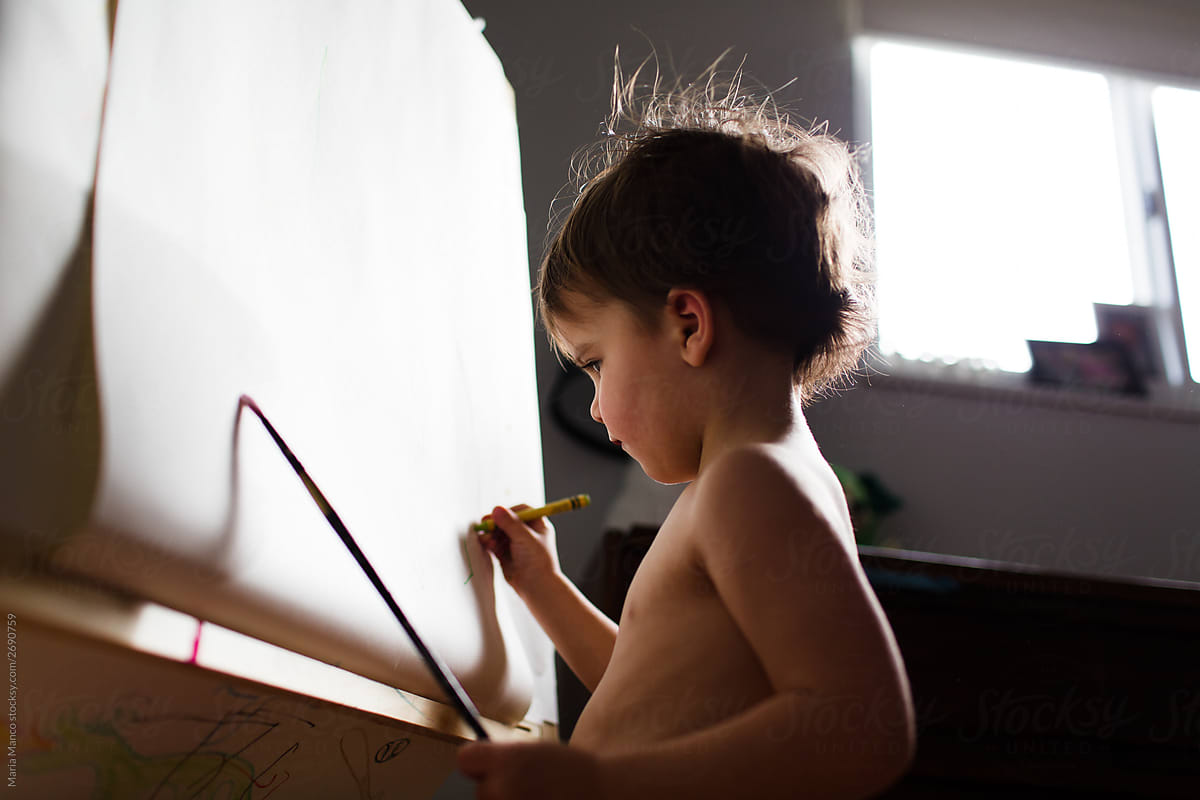 little boy draws at easel