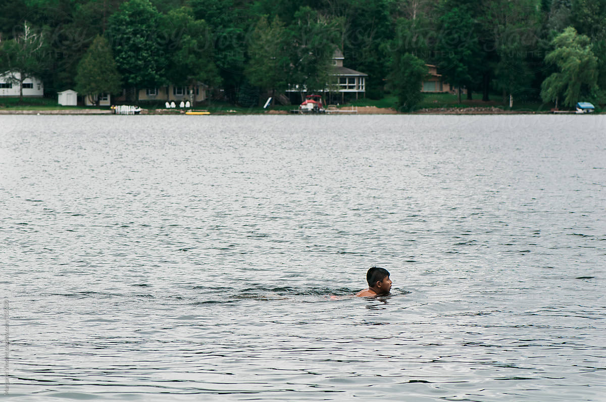 boy swimming in lake