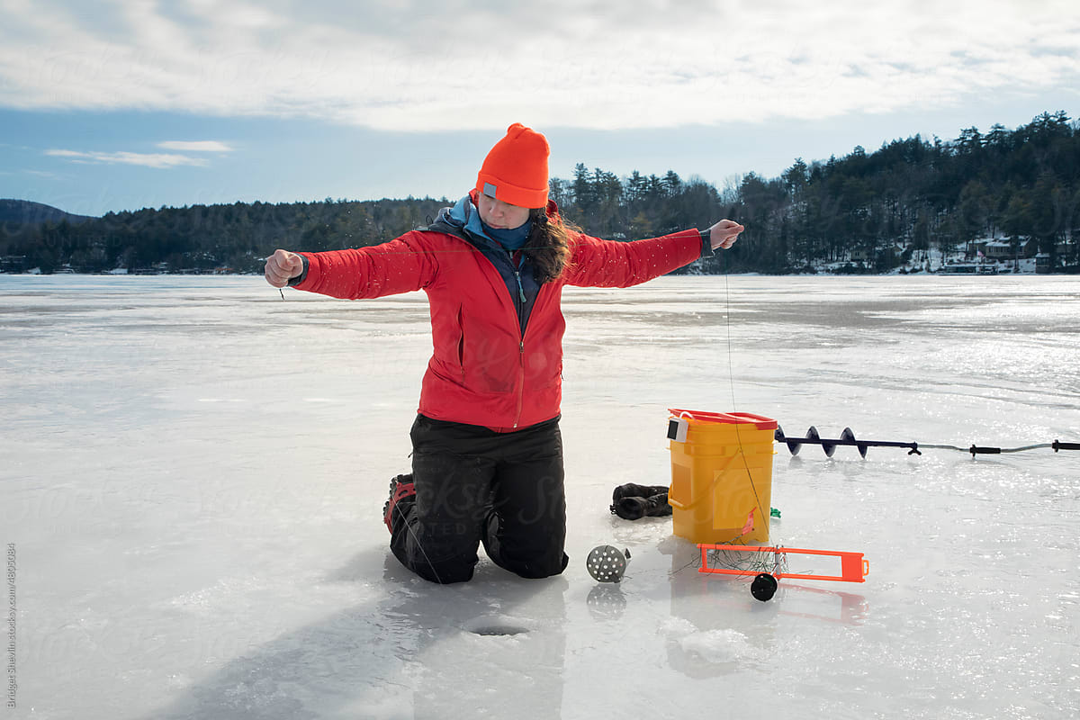 Woman ice fishing on a lake