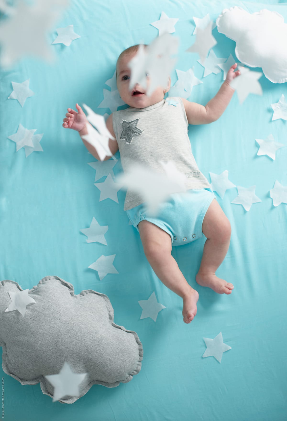 Baby playing with crafted stars and clouds