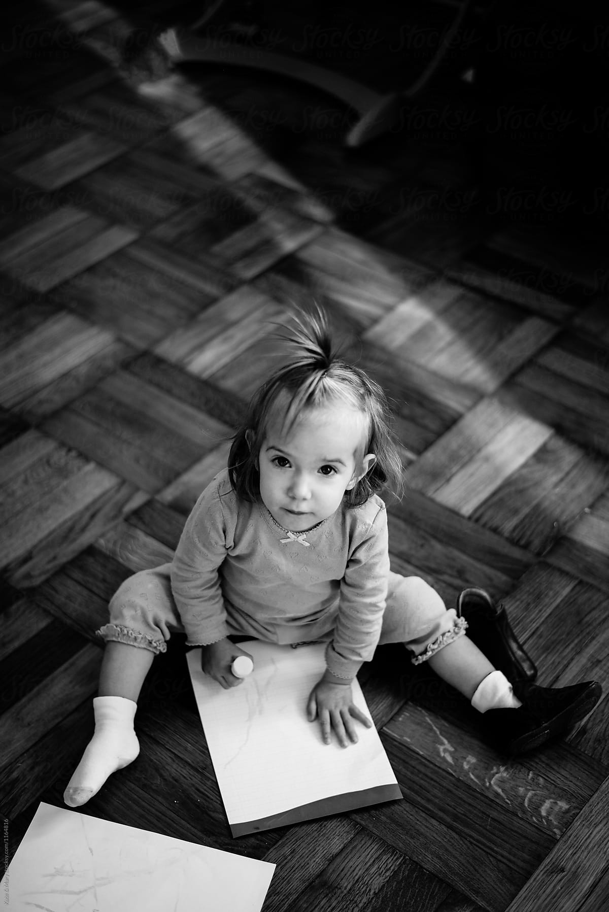 Portrait of beautiful baby drawing on floor