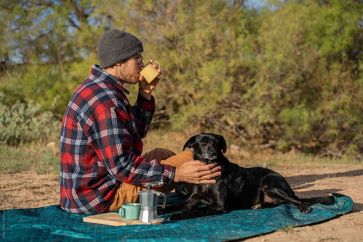Man and dog having coffe in the middle of desert