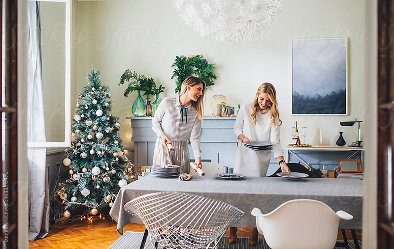Two Women Setting Up The Table For Christmas Dinner