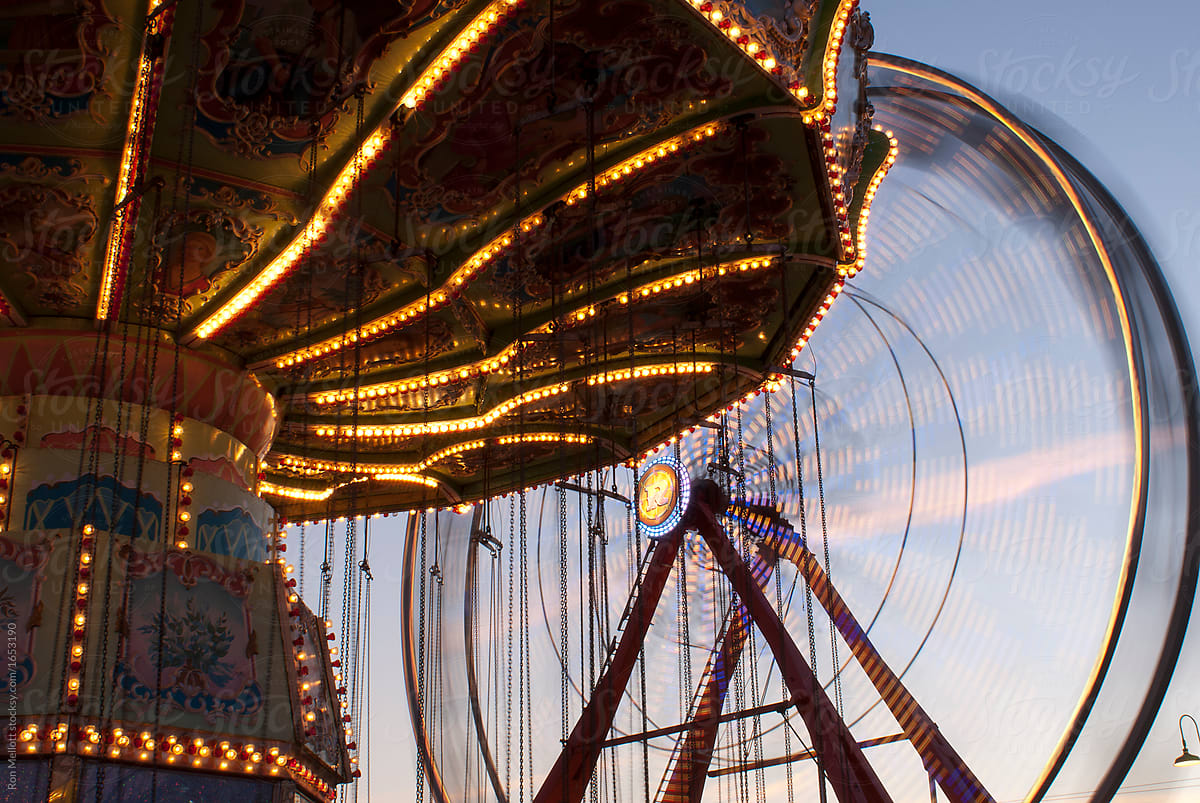 ferris wheel and carousel in late afternoon at a fair carnival