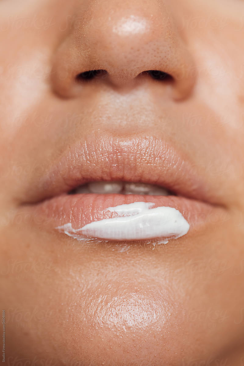 Woman's lip covered with facial cream