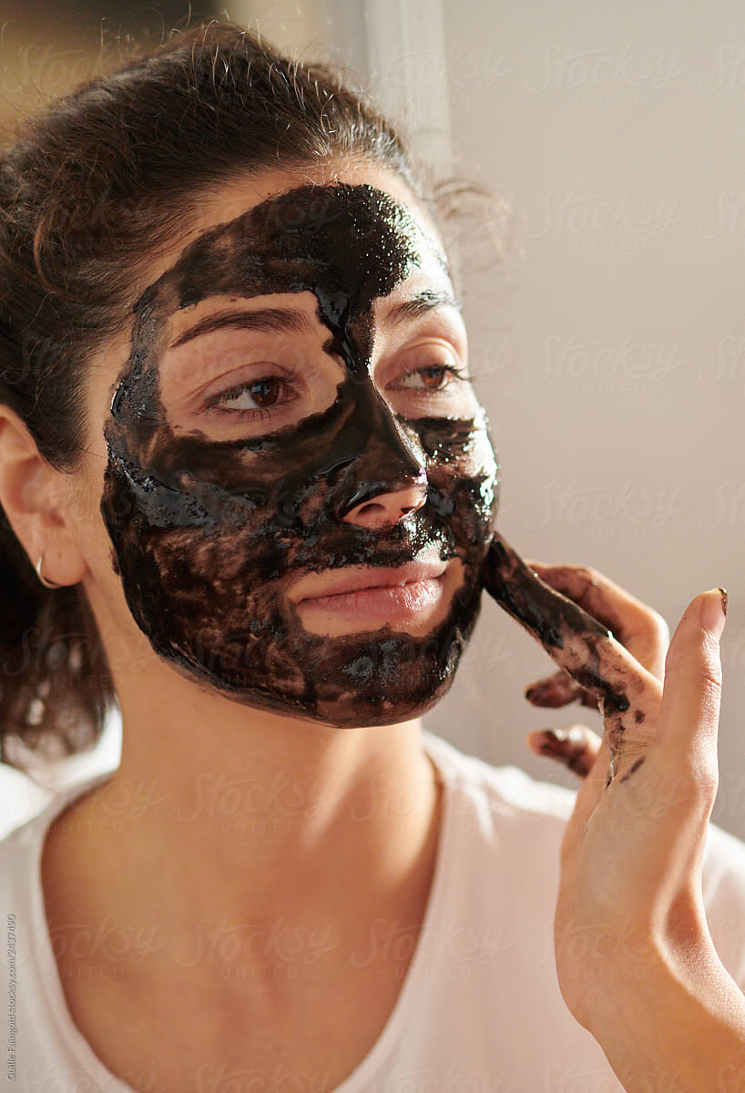 Crop girl applying mask on face of girlfriend