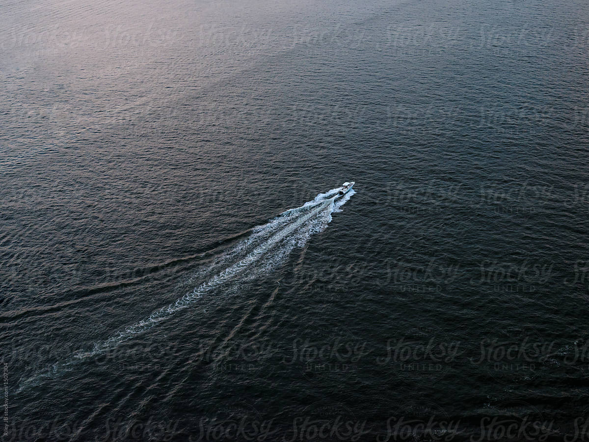 A motorboat cruising down the Hudson river from above.