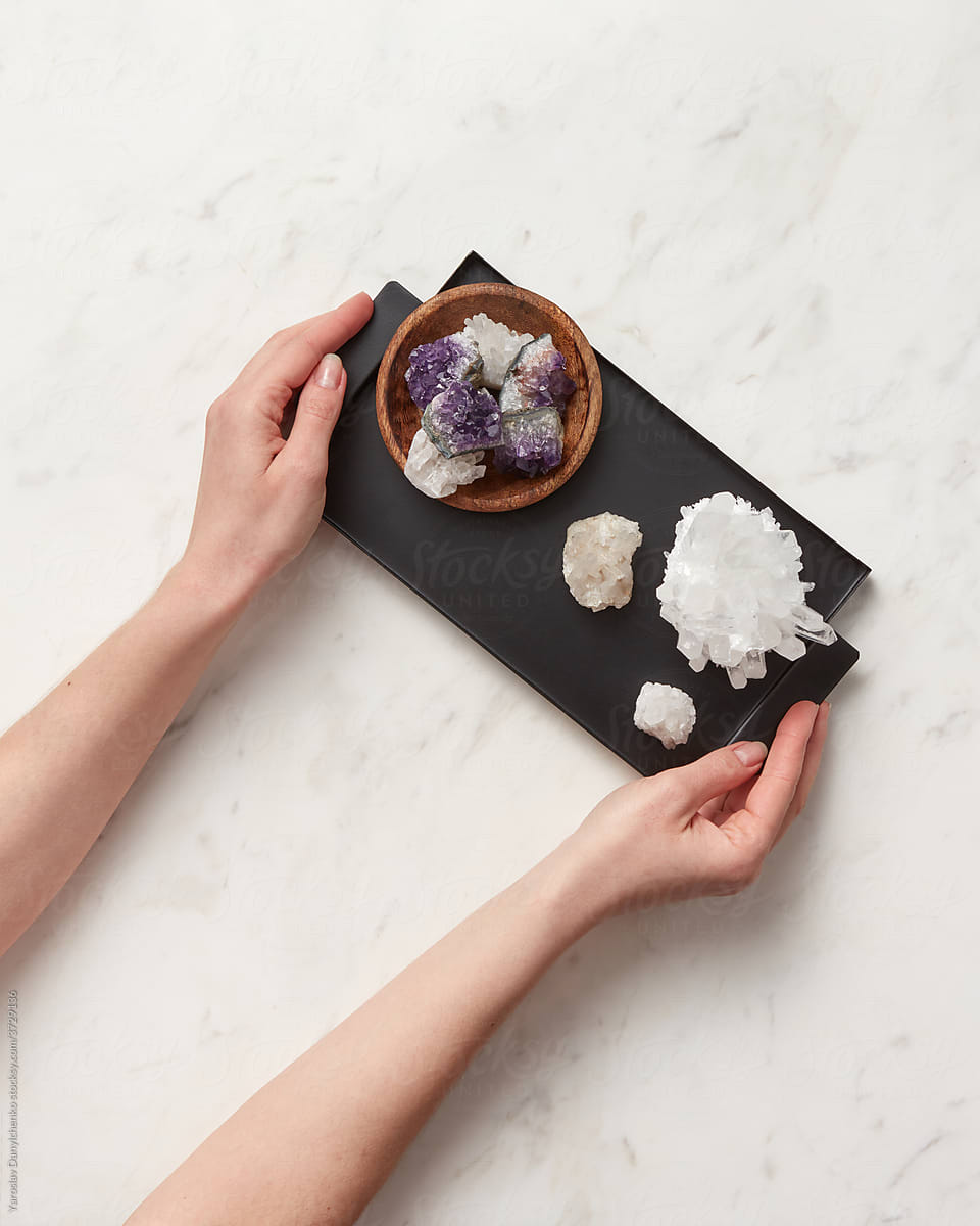 Woman holding tray with quartz and amethyst crystals