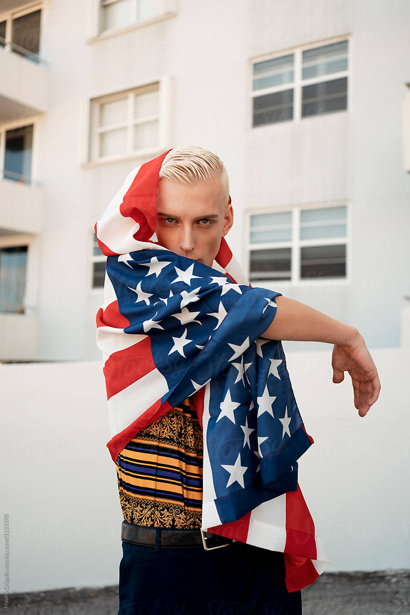Stylish blond man playing with an american flag