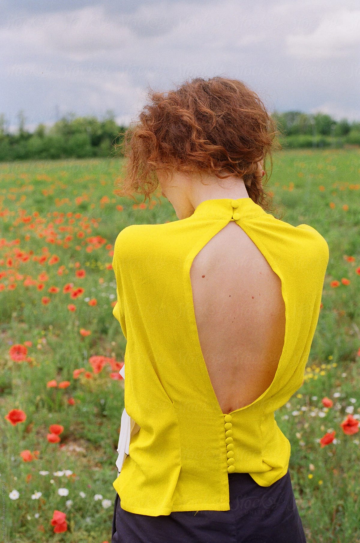 Back of a stylish woman wearing bright yellow gown