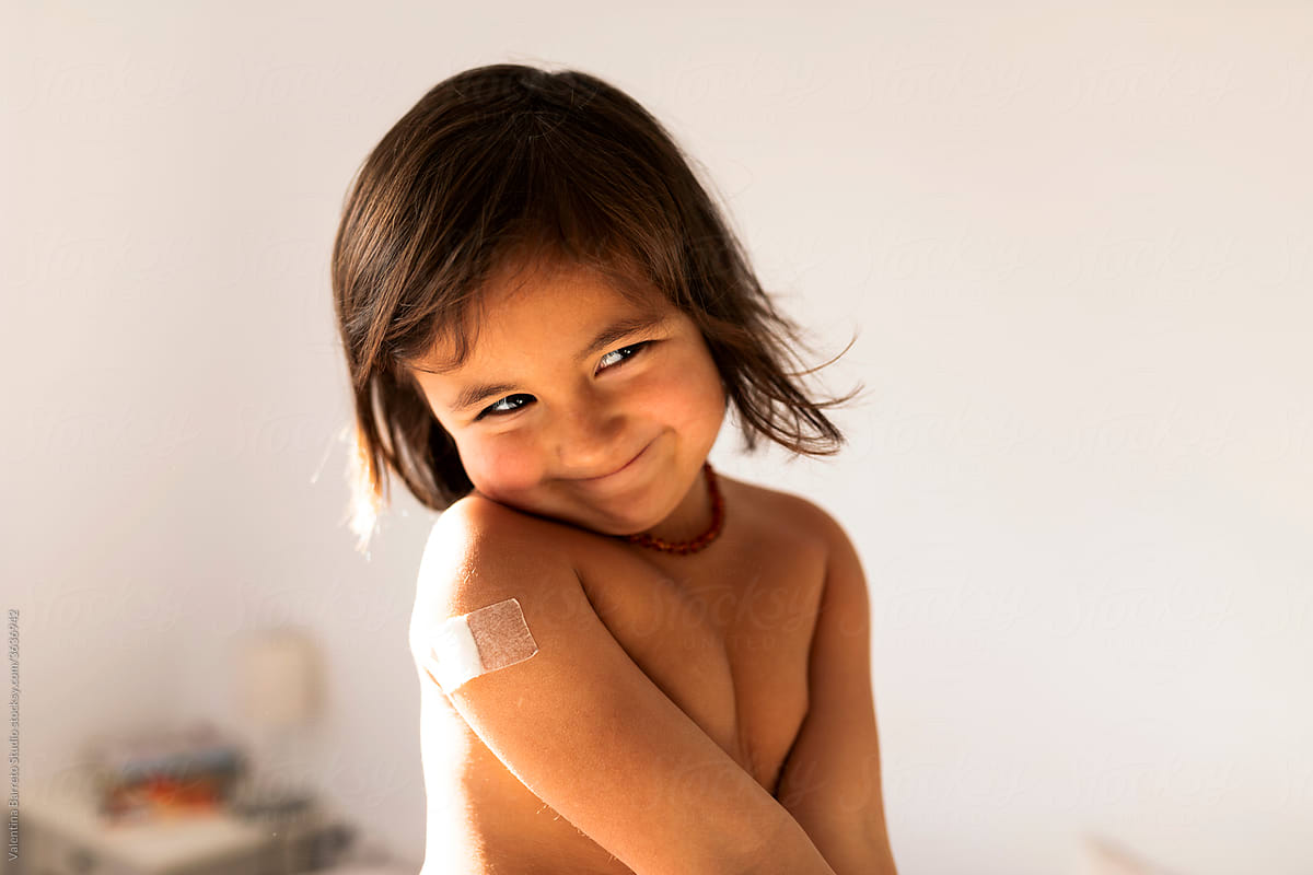 smiling little girl with a band aid in her arm