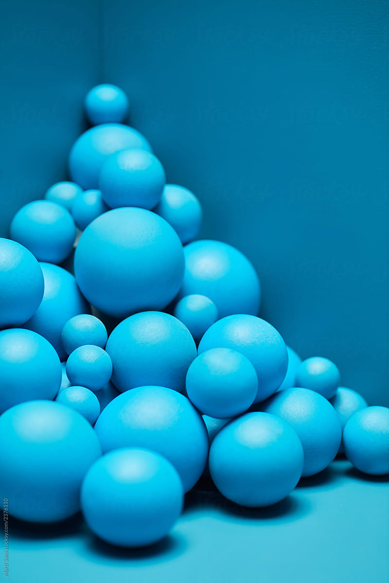 Pile of various blue spheres in corner