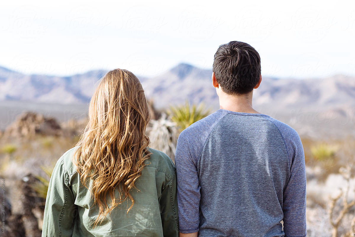 Couple facing away from the camera in desert