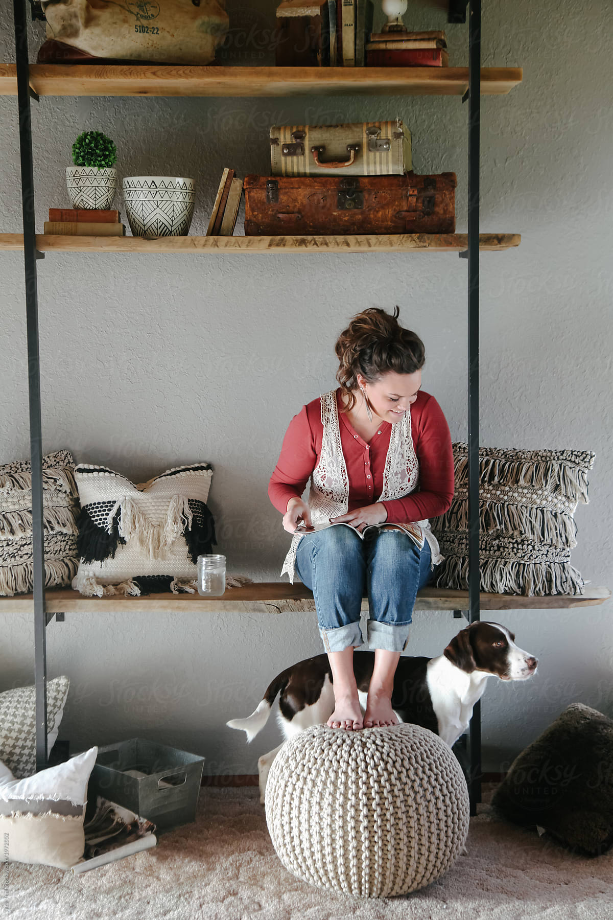dog stands near woman leisurely reading magazine at home