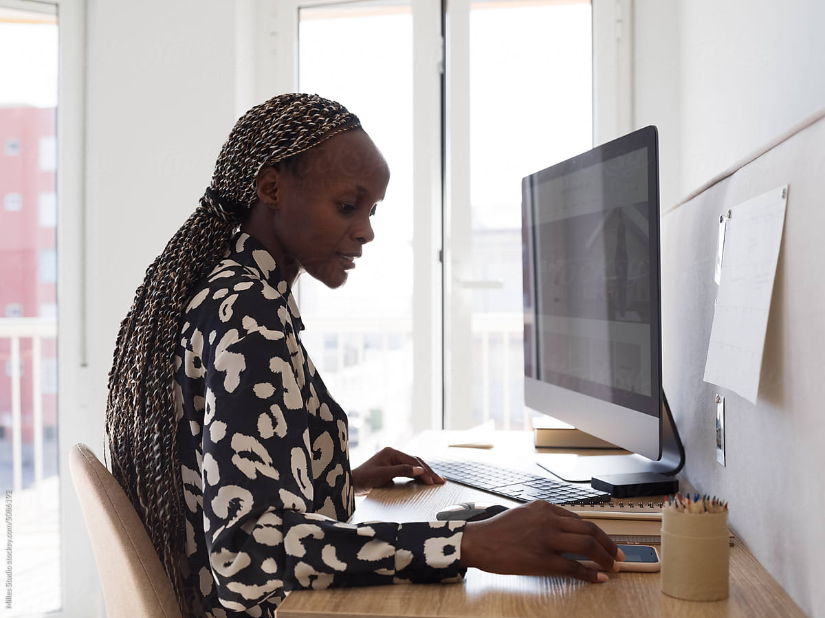 Black female freelancer using smartphone during work