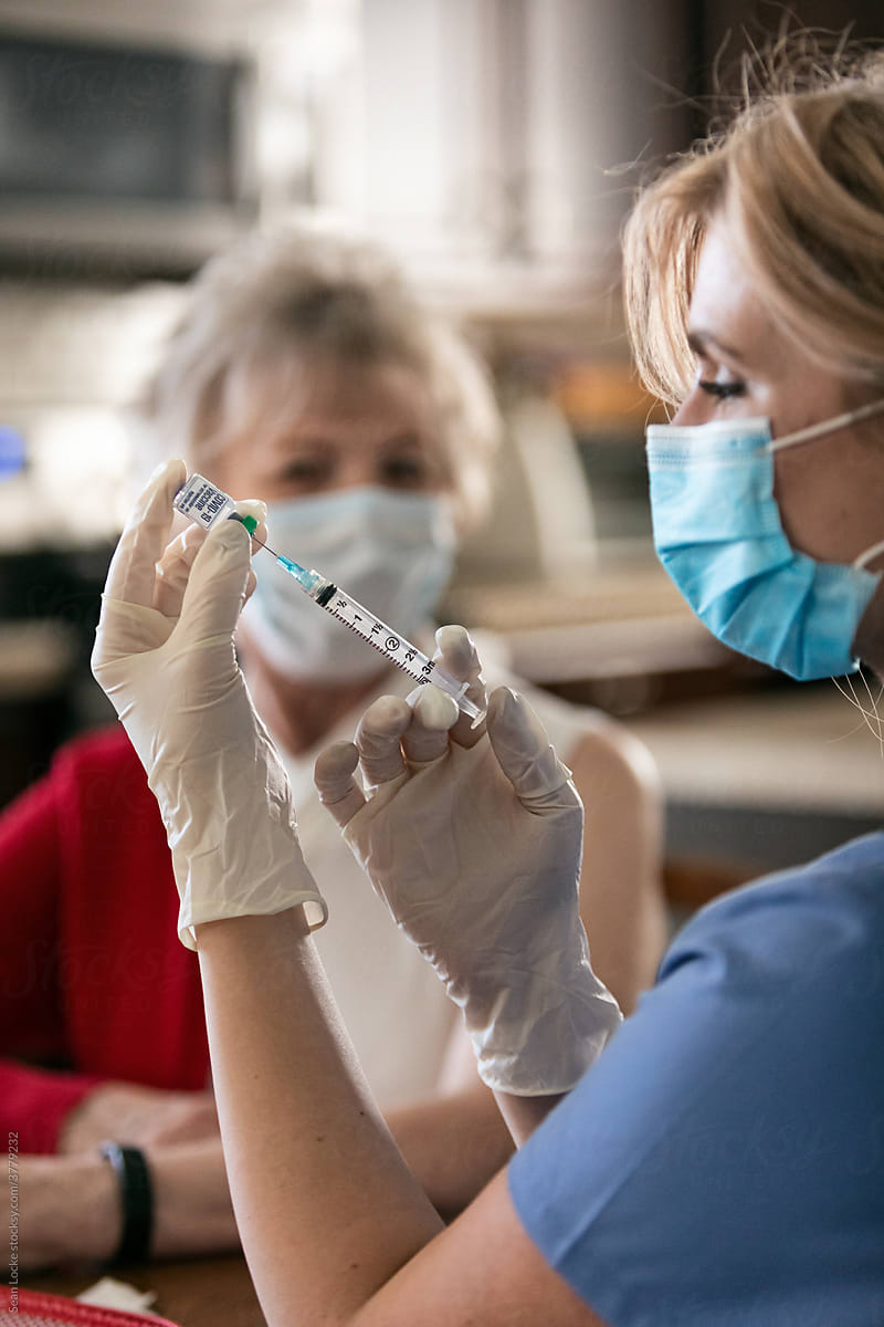 Health: Nurse Readies To Vaccinate Senior In Her Home