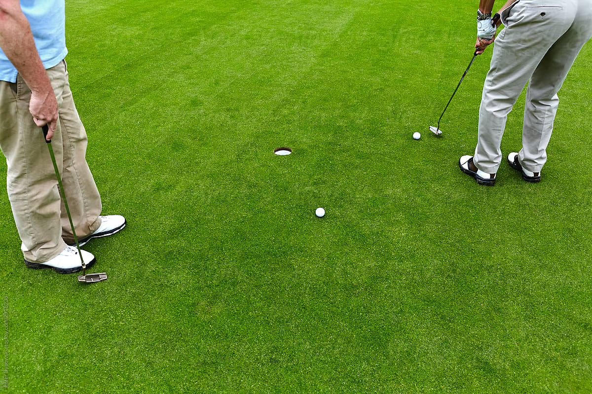Two men playing golf detail.