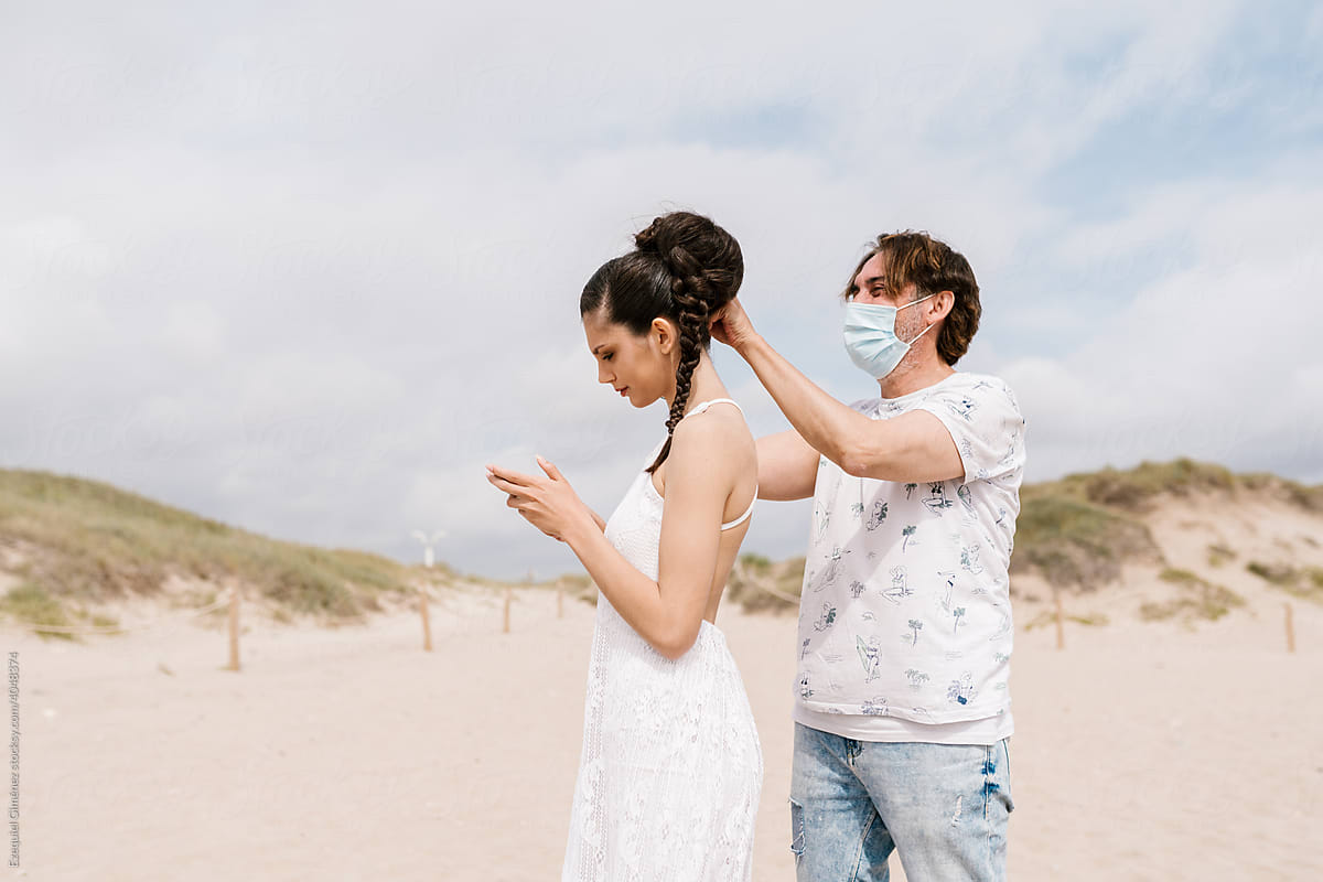 Stylist grooming bride looking at smart phone