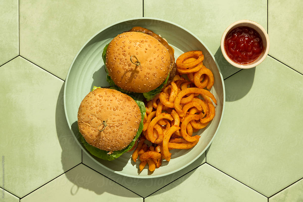 Burgers in green plate on tile background