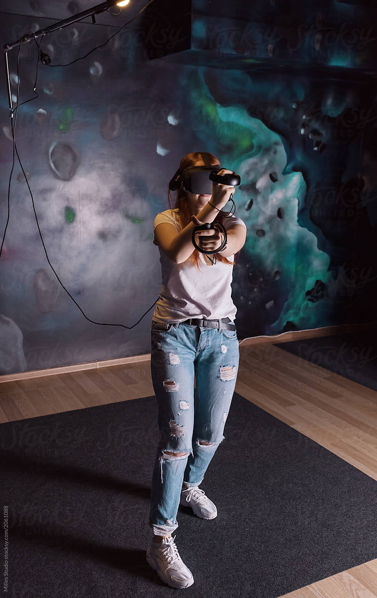 Young woman playing VR game in headset
