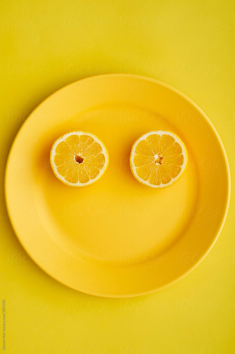 Sliced lemon on yellow plate.