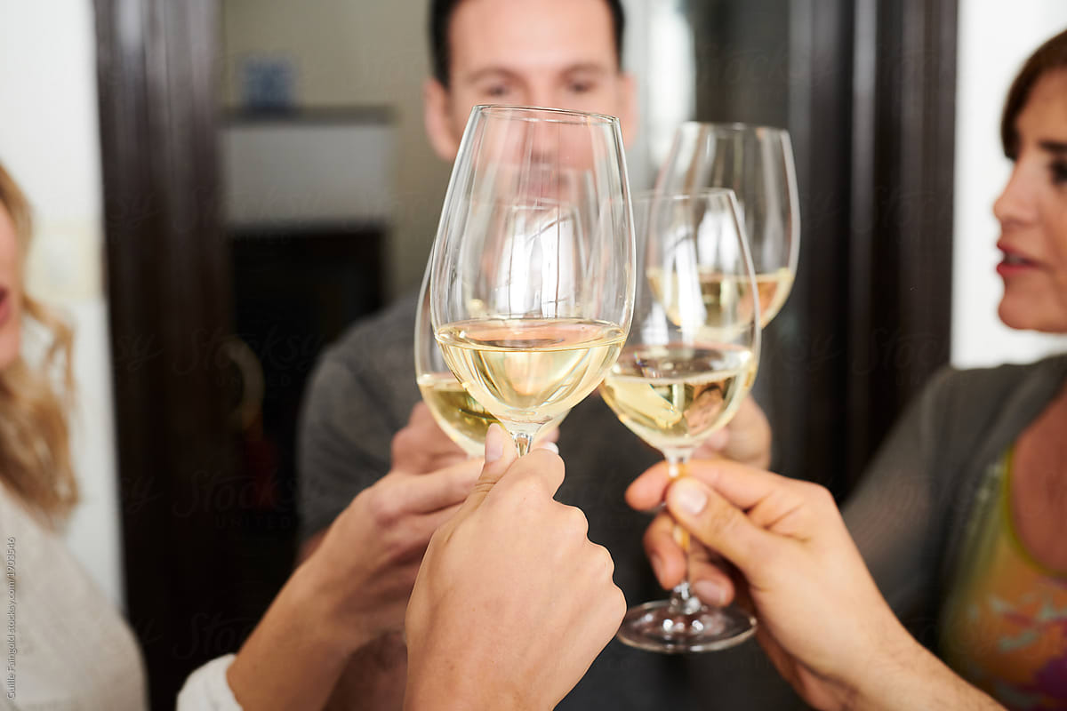 Close-up of friends toasting with champagne or wine.