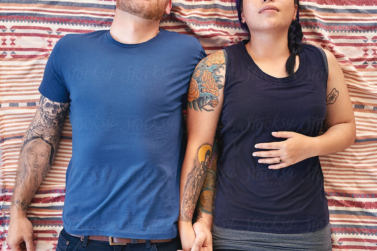 Couple with tattoos holding hands