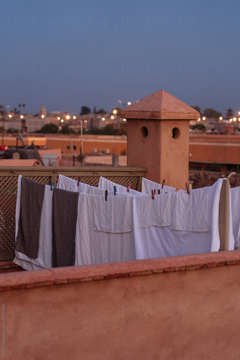 Bed sheets hanging from clothesline on roof of Arabian building