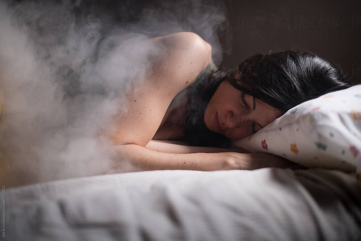 Dreamy portrait of woman sleeping inside smoke cloud
