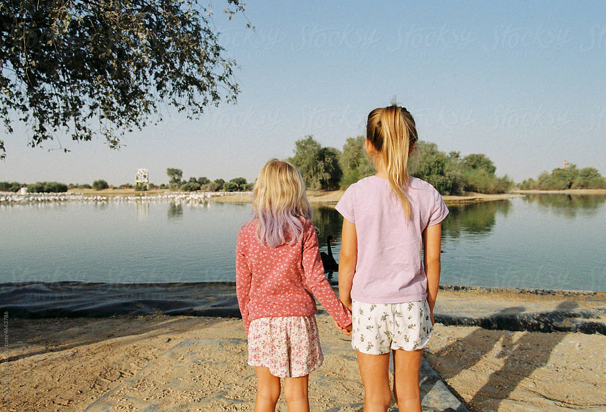 Two girls on the lake with flamingoes