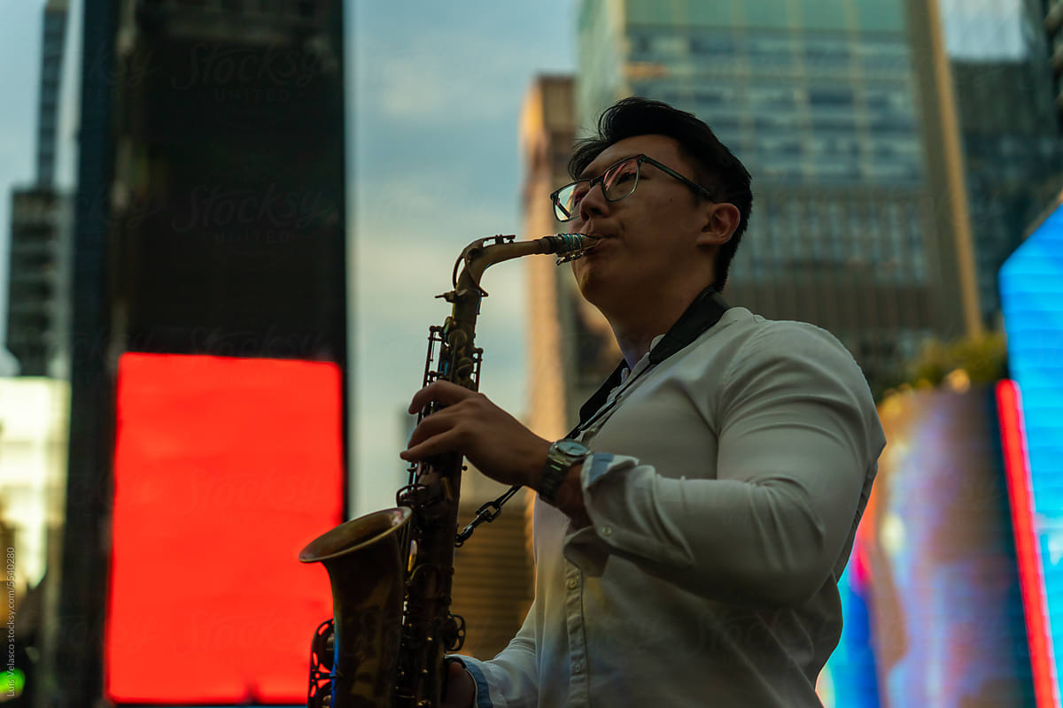 Passionate Man Playing The Saxophone On The Street At Sunset.