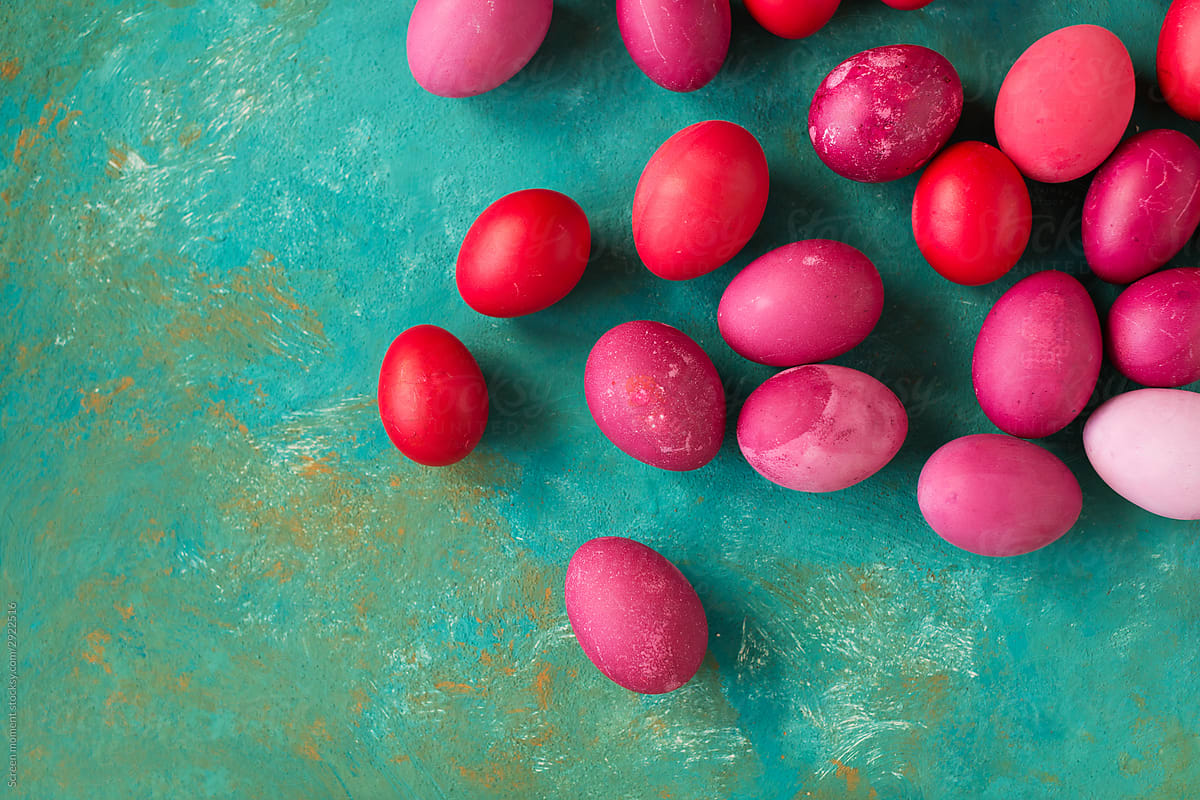 Pink and red Easter eggs on green background. Copyspace. Still life photo of lots of pink easter eggs.Background with easter eggs.  Easter photo concept