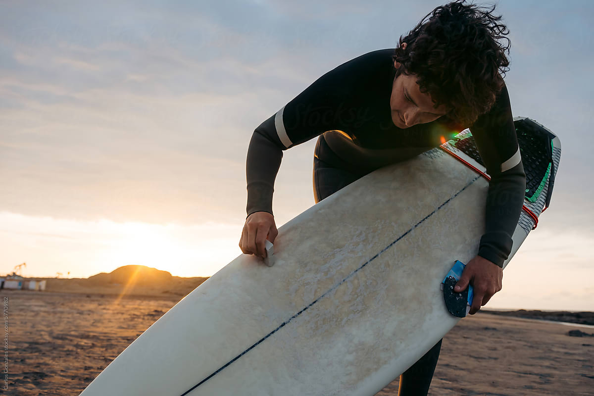 Surfer waxing his board