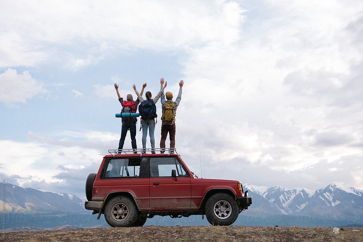 Content travelers posing on car