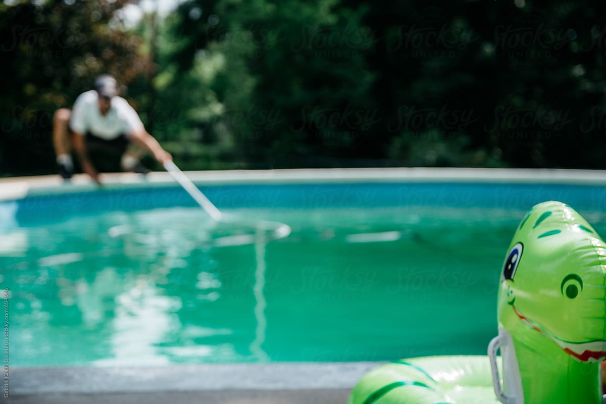 Pool maintenance worker cleaning a pool