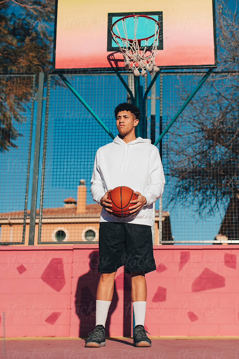 A young man on a pink basketball court