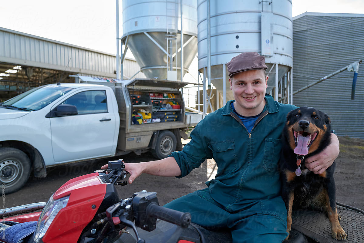 Dairy Farmer sitting on quad bike with farm dog