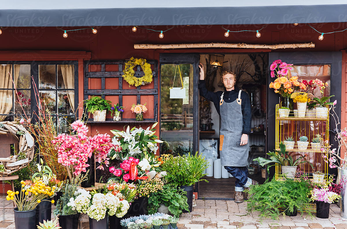 Flower shop owner in storefront around flowers