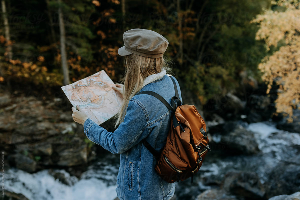 woman with a map exploring the mountains