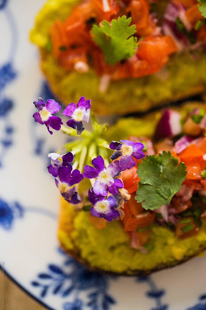 Toast with guacamole and decorative flowers.