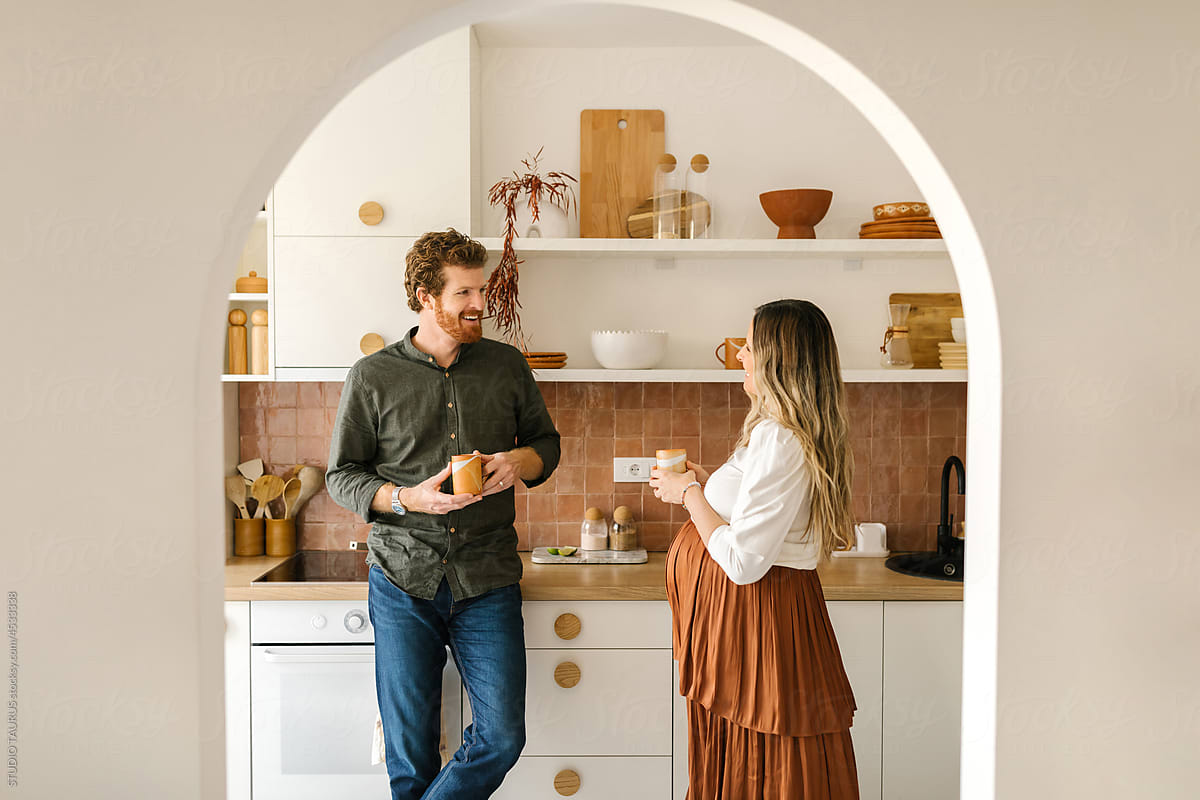 Caucasian, smiling, pregnant couple in the kitchen