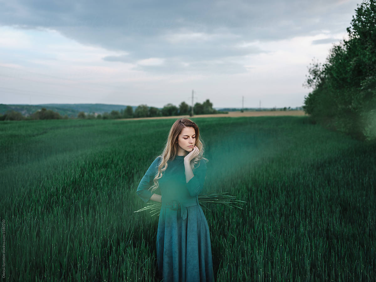 Young girl posing among green field
