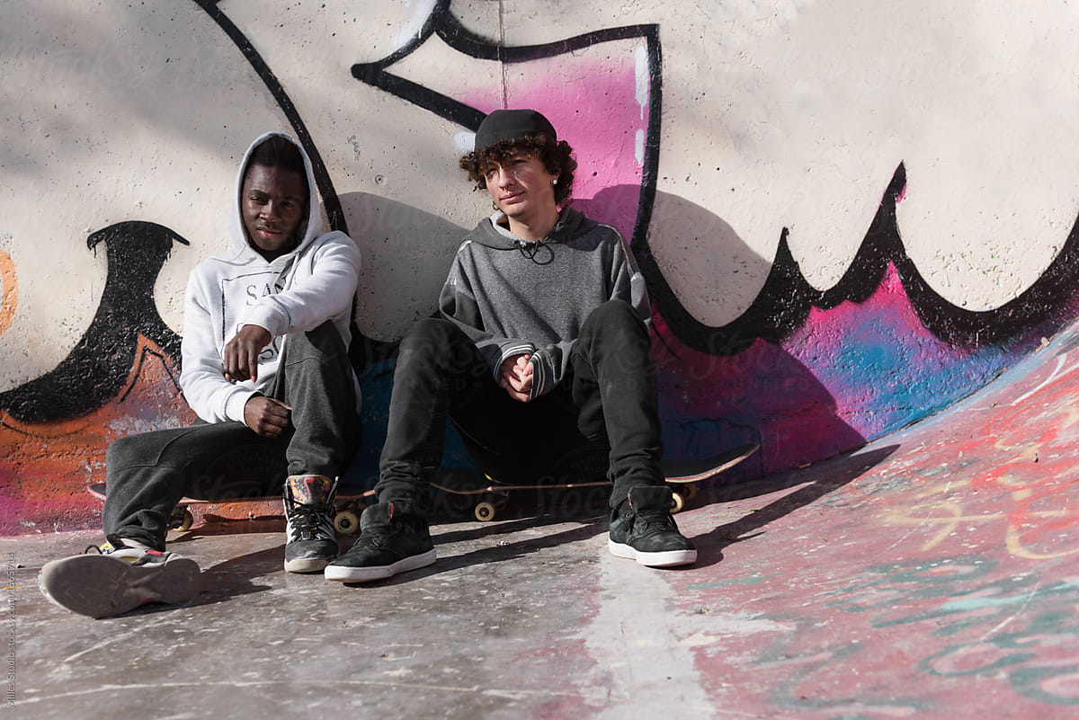 Young skateboarders sitting on boards
